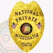 A detailed view of a custom metal badge in gold color with a safety pin attachment, highlighting the words "NATIONAL PRIVATE INVESTIGATOR." The badge's design incorporates the Alabama state seal and decorative flags, showcasing its craftsmanship and professional appeal.